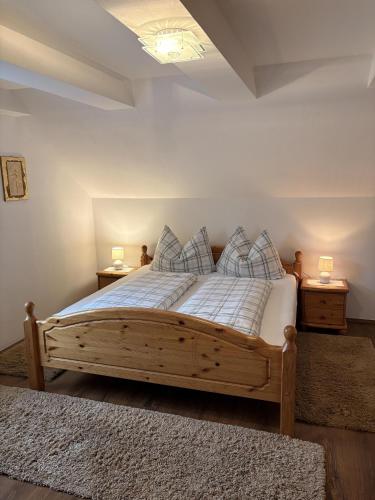 a bedroom with a wooden bed with pillows on it at Gästezimmer Schupanez in Leutschach
