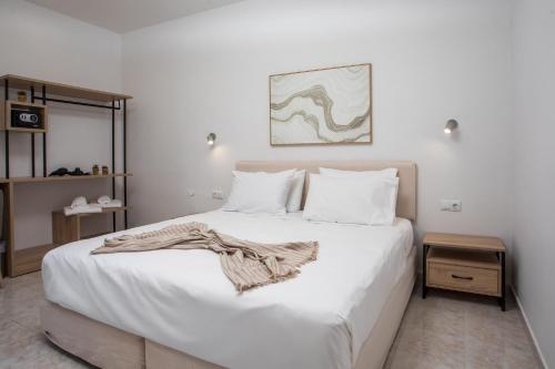 a bedroom with a large bed with white sheets at Olevia Comfort in Faliraki