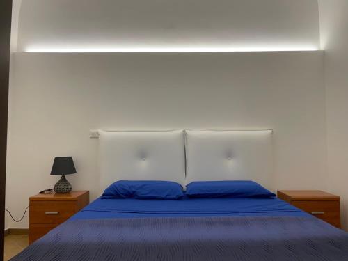 a bedroom with a blue bed with two night stands at Msholiday home in Cinisi