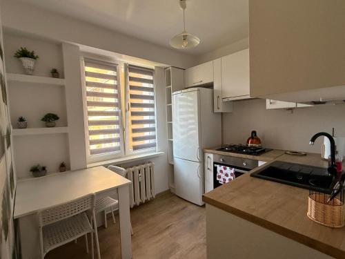 a kitchen with white cabinets and a white refrigerator at Apartament Mazury in Kętrzyn