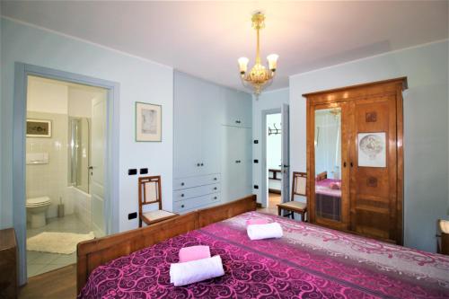 a bedroom with a pink bed and a bathroom at Holiday Home Lake Orta in Pettenasco