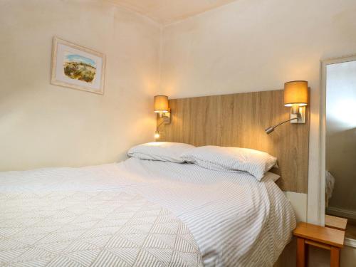 a bedroom with a large white bed with two pillows at Vine View in Halesworth