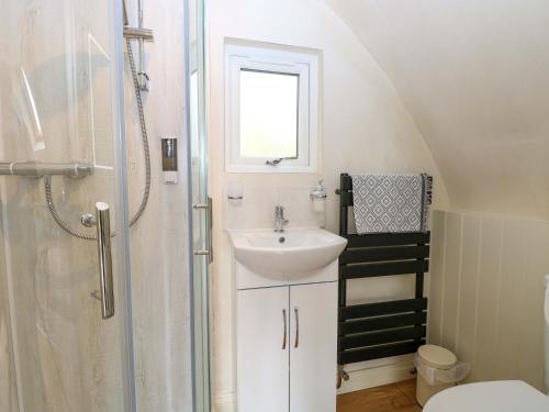 a small bathroom with a sink and a shower at Vine View in Halesworth