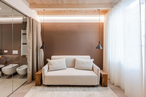 a living room with a white couch and a bathroom at Margherita Home in Reggio Emilia