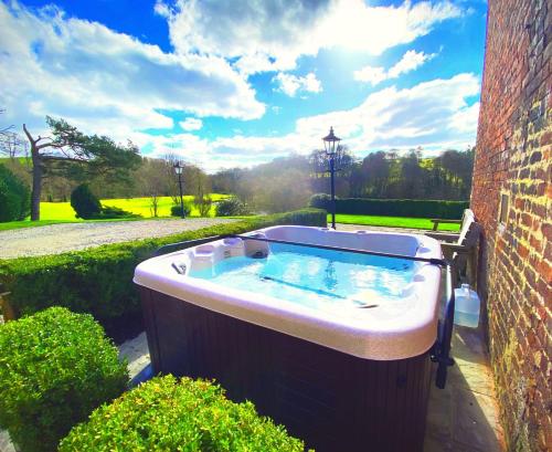 a hot tub in the side of a building at Bettws Hall Accommodation in Newtown