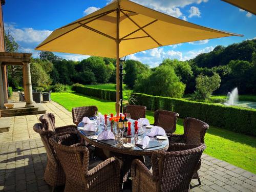 a table with a yellow umbrella on a patio at Bettws Hall Accommodation in Newtown