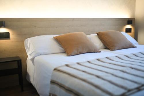 a bed with two pillows on it in a room at A Casa da Toura in Puentedeume