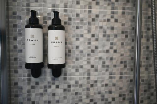 two bottles of wine hanging on a tiled wall at A Casa da Toura in Puentedeume