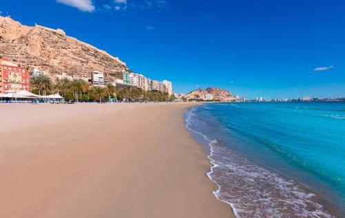 a sandy beach with buildings and the ocean at Central & Spacious Miraflores Alicante - High Rated in Alicante