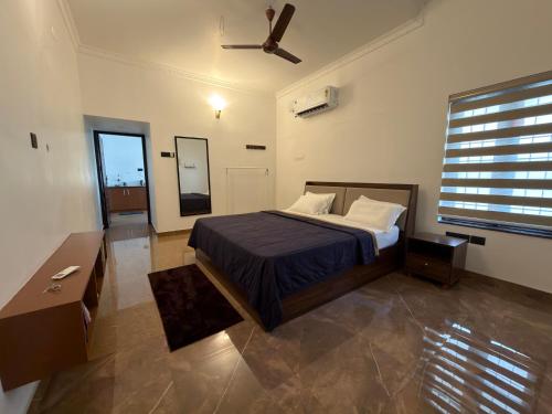 a bedroom with a bed and a ceiling fan at The Golden, Apartrooms in Trivandrum