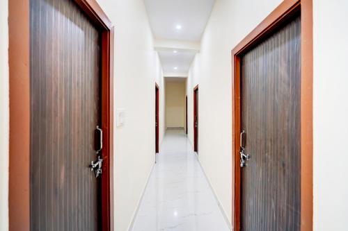 an empty corridor with two doors at Hotel O Hotel Denmark in Chinhat