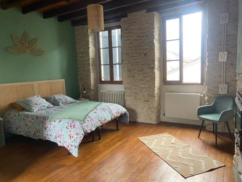 a bedroom with a bed and a chair in it at Le Caillou in Reuilly