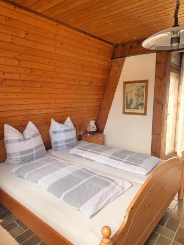 a bed in a room with a wooden ceiling at Gästezimmer Ferienhaus Waldblick in Sonnenbühl