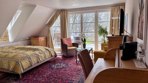 a bedroom with a bed and a desk and window at ArtVilla am See - offen März bis Ende Oktober in Radolfzell am Bodensee
