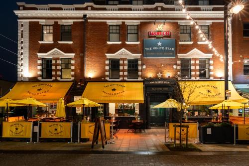 a restaurant with tables and umbrellas in front of a building at The White Star Tavern in Southampton