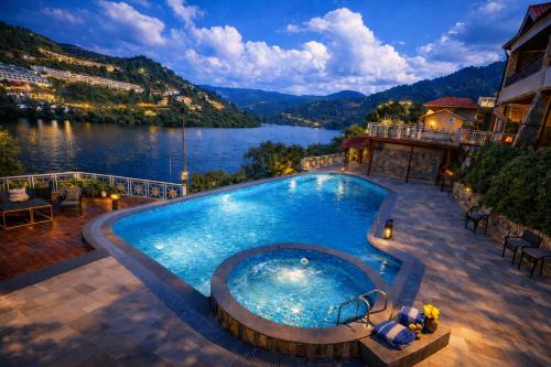 a swimming pool with a view of a lake at Neelesh Inn - Luxury Lake View Resort with Swimming Pool on Bhimtal Lake in Bhīm Tāl