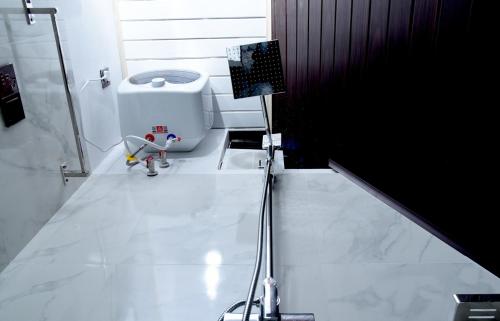 a white bathroom with a toilet and a camera at Infinite cabana in Ella