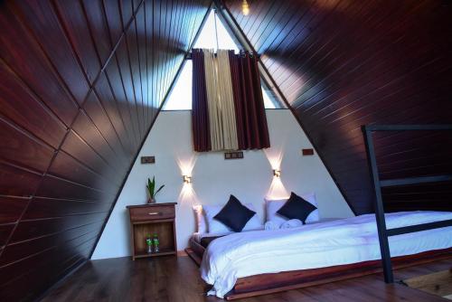 a bedroom with a bed in a triangle shaped room at Infinite cabana in Ella