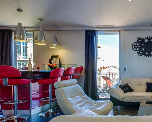 un soggiorno con bar con sedie rosse di RG Duplex - Sea View - Palais & Croisette - Luxury Stay by LRA Cannes a Cannes