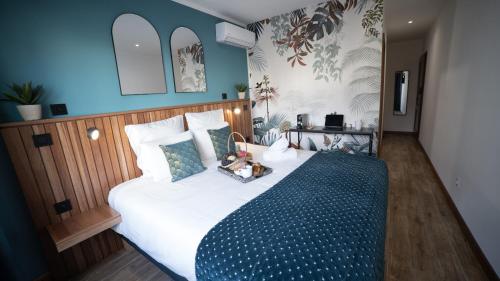 a bedroom with a large bed with a blue blanket at Maison le patio in Saint-Denis
