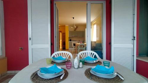 a table with two chairs and blue dishes on it at TRILOCALE DIRETTAMENTE SUL MARE - cod 512 in Porto Recanati