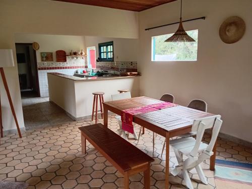 a kitchen with a wooden table and chairs in it at Casa Morro Branco in Palmeiras