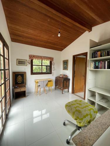 a living room with a table and a chair at Casa Morro Branco in Palmeiras