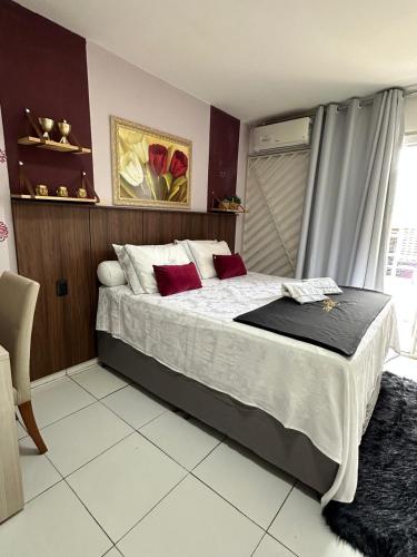 a bedroom with a large bed with red pillows at Flat JK 103 in Juazeiro do Norte