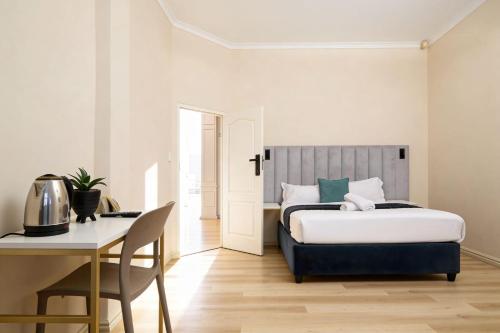 a bedroom with a bed and a table and a desk at The City Club in Cape Town