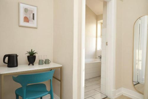 a bathroom with a blue chair sitting at a desk at The City Club in Cape Town