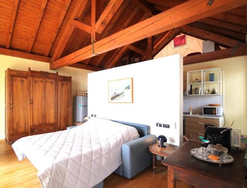 a bedroom with a bed and a table in a room at Holiday Home Lake Orta in Pettenasco