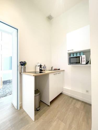 a white kitchen with a counter and a microwave at Suite Luxe · Cour calme · Chartres centre in Chartres