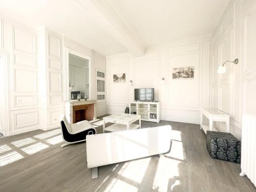a white living room with a couch and a table at Suite Luxe · Cour calme · Chartres centre in Chartres