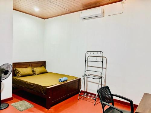 a bedroom with a bed and a ladder and chairs at Thew Guest Wilpattu in Nekattegama