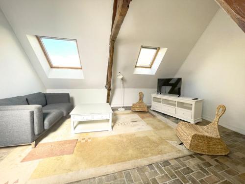 a living room with a couch and a tv at La Chapelle · Vue cathédrale · Chartres centre in Chartres