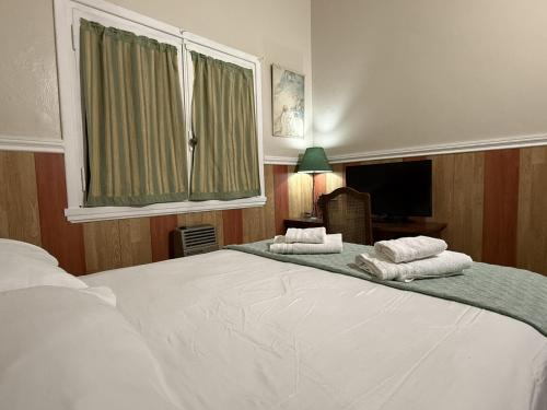a bedroom with a large white bed with towels on it at Cuatro Soles in Ezeiza