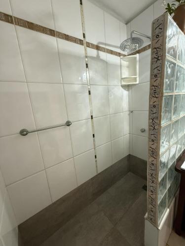 a bathroom with a shower with white tiled walls at Cuatro Soles in Ezeiza