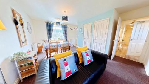 a living room with a couch and a dining room at Lighthouse Apartment - Part of the The Bay Filey Holiday Village with pool, gym and direct beach access, pub, restaurant, tennis and meadows walks in Filey
