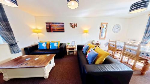 a living room with two couches and a table at Lighthouse Apartment - Part of the The Bay Filey Holiday Village with pool, gym and direct beach access, pub, restaurant, tennis and meadows walks in Filey