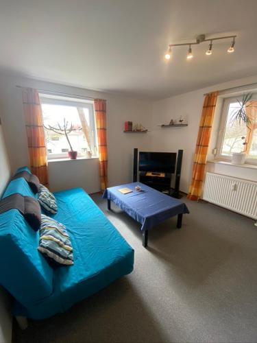 a living room with a blue couch and a table at Fewo 4 in Markkleeberg