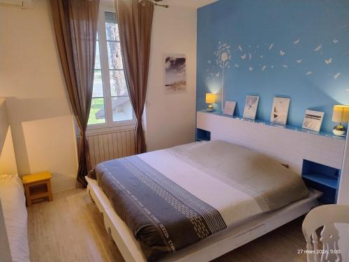 a bedroom with a bed and a blue wall at Chambre d'hôtes Park des Collines - Gîte in Génissieux