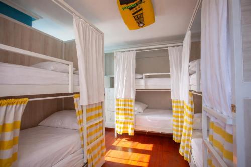 two bunk beds with drapes in a room at Gijon Surf Hostel in Gijón