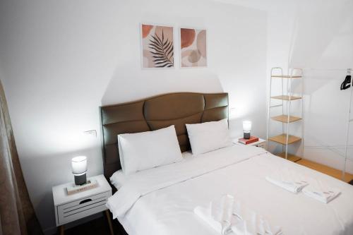 a bedroom with a large white bed with white sheets at Exclusive Villa Jacuzzi & BBQ in Şerbăneşti