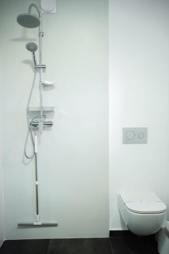 a white bathroom with a shower and a toilet at Exclusive Villa Jacuzzi & BBQ in Şerbăneşti