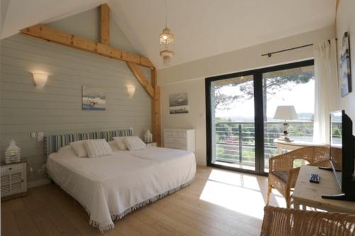 a bedroom with a large white bed and a desk at Kerlenn in Baden