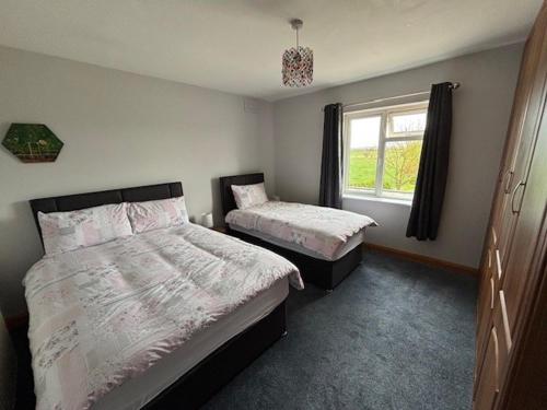 a bedroom with two beds and a window at Fiona's Country Accommodation in Murphyʼs Bridge