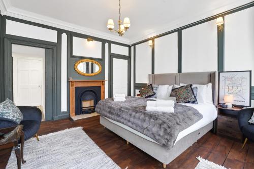 a bedroom with a large bed and a fireplace at The Library at The Merchants in Fenwick