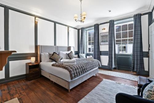 a bedroom with a bed and some windows at The Library at The Merchants in Fenwick