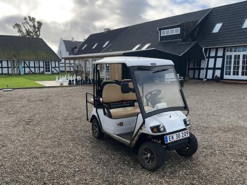 a small white golf cart parked in front of a building at 4 star holiday home in Svendborg in Svendborg