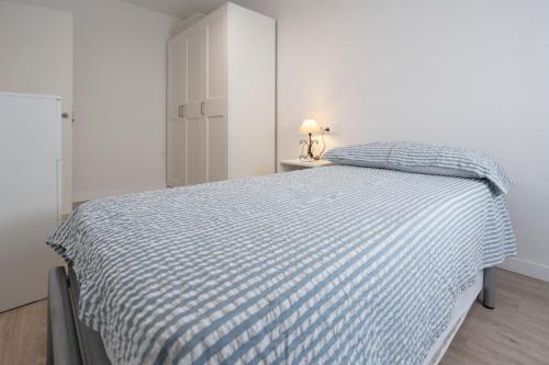 a bedroom with a bed with a blue and white comforter at Playa Anaconda - Wellhome Alicante in Benimagrell